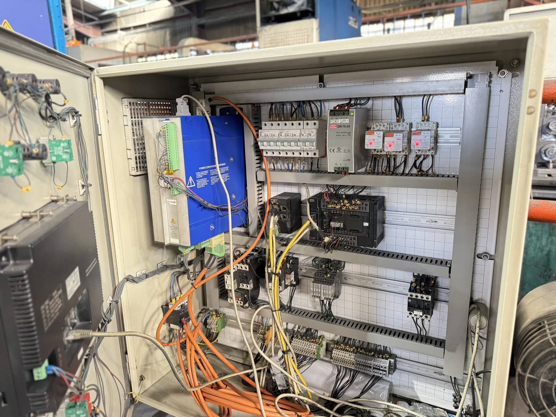 Open industrial control cabinet with PLC and power hardware